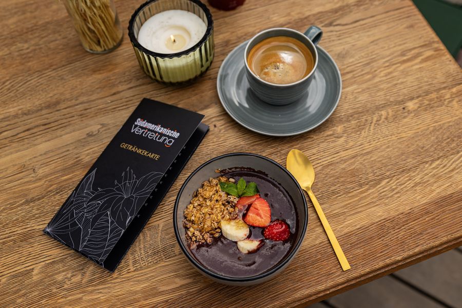 Açaí-Bowl mit Granola und Früchten, dazu Kaffee