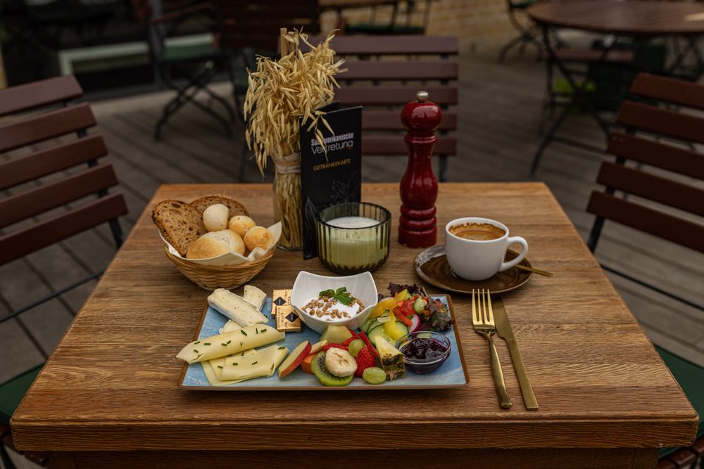Kleines Frühstück mit Käse, Brot, Obst und Joghurt