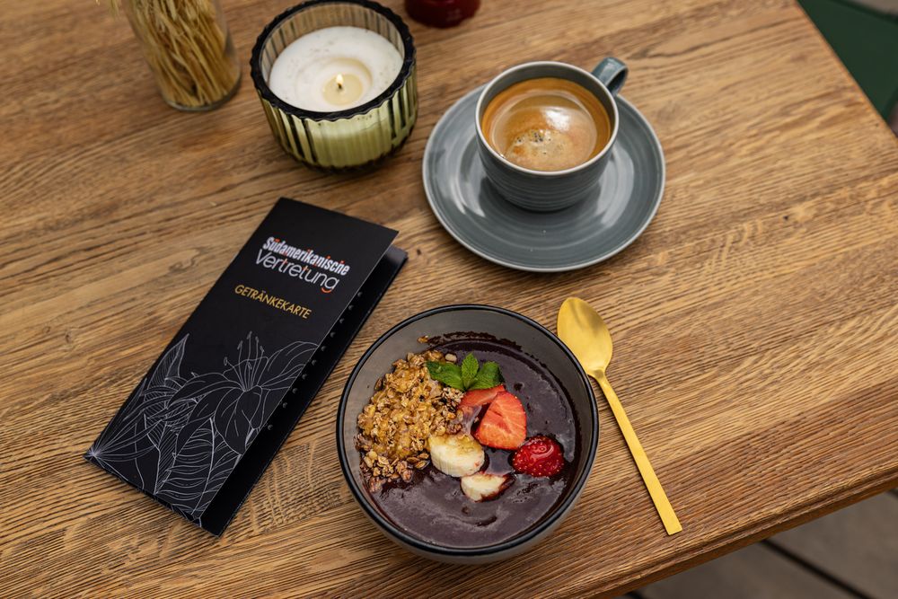 Açaí-Bowl mit Granola und Früchten, dazu Kaffee